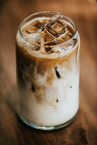 an iced drink in a glass on top of a wooden table