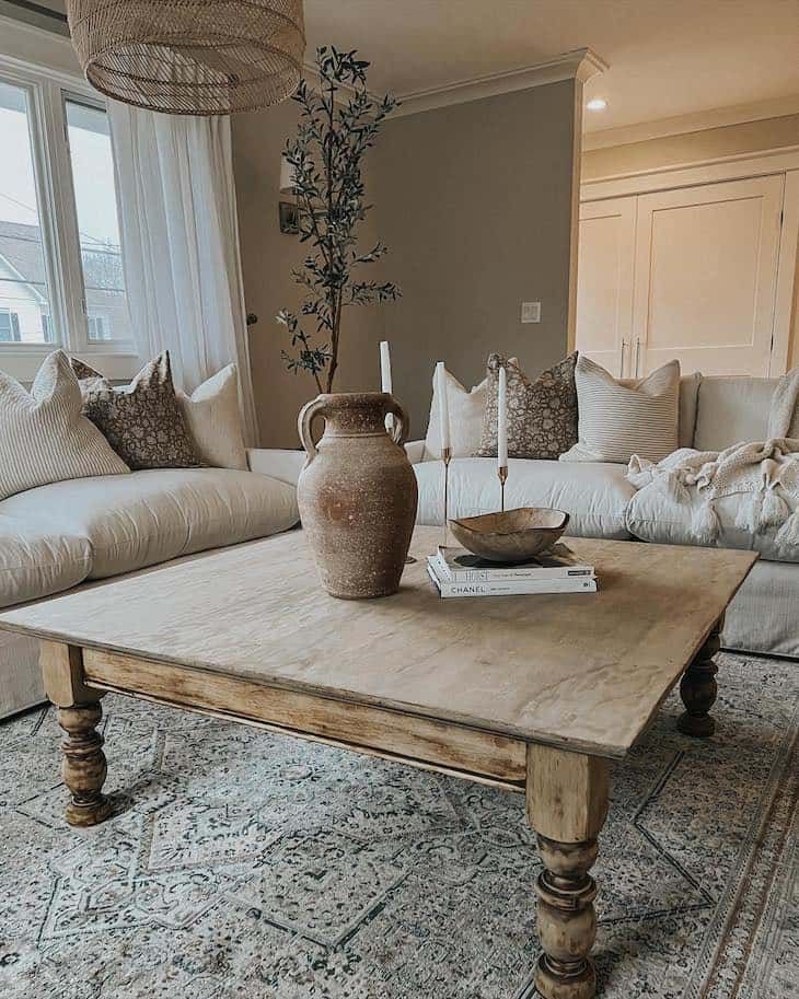 a living room filled with furniture and a large vase on top of a coffee table