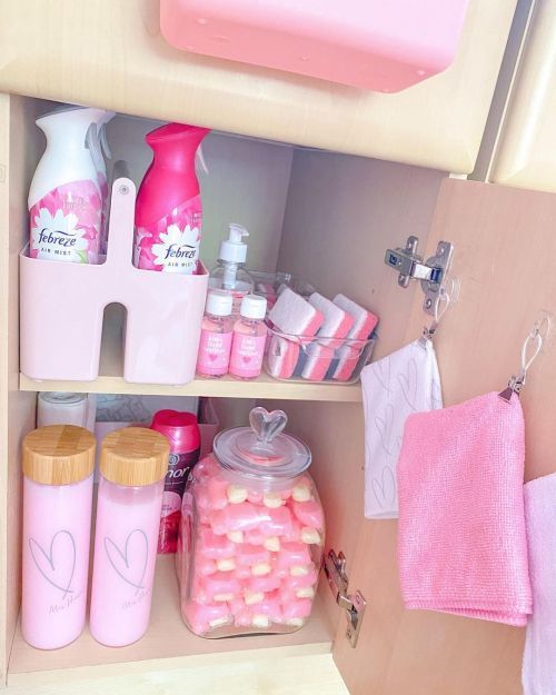 a bathroom cabinet filled with lots of pink items