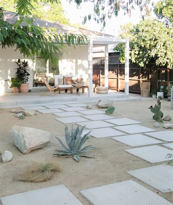 a patio with rocks and plants in the middle