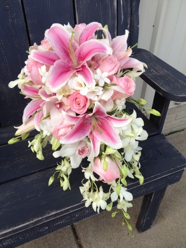a bouquet of pink and white flowers on a bench