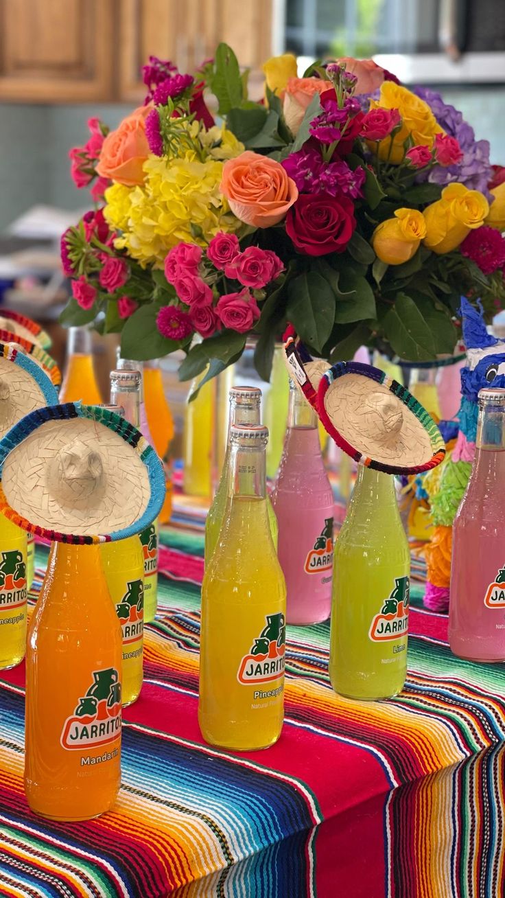 a table topped with bottles of soda and flowers