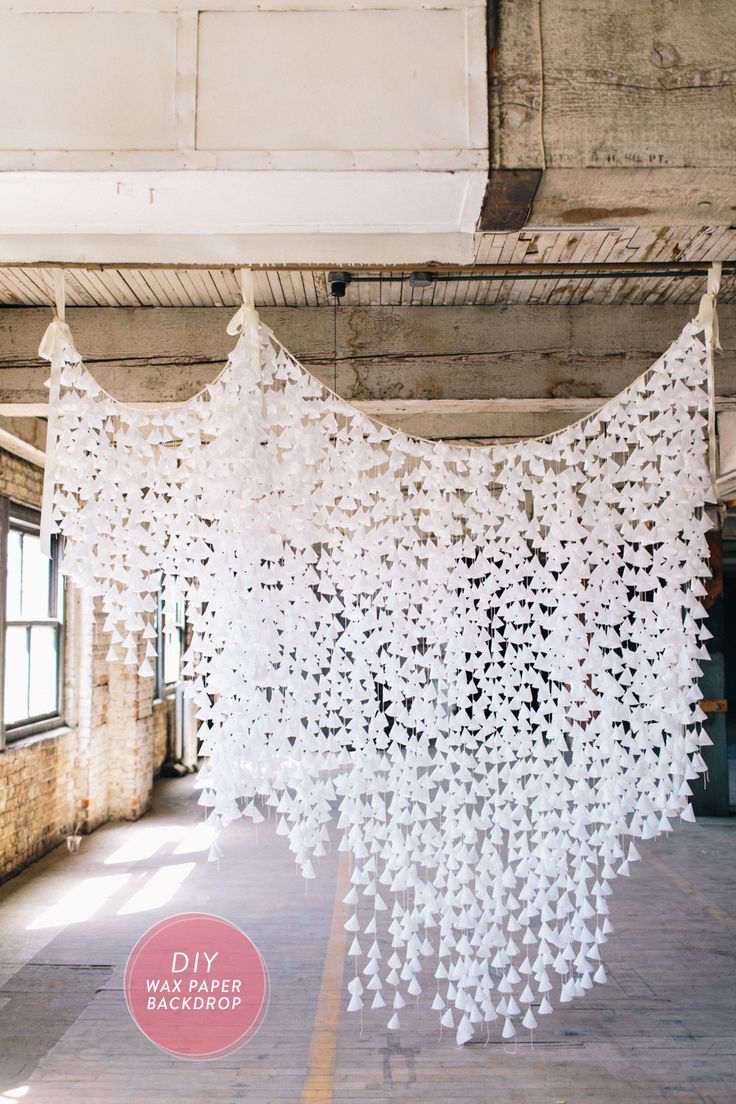 an art installation made out of white crochet hanging from the ceiling in a building