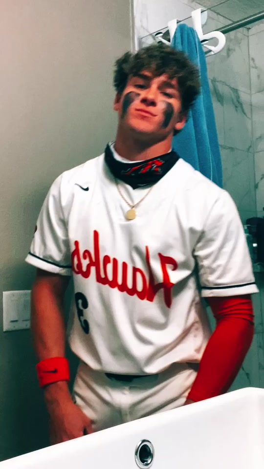 a baseball player standing in front of a bathroom sink