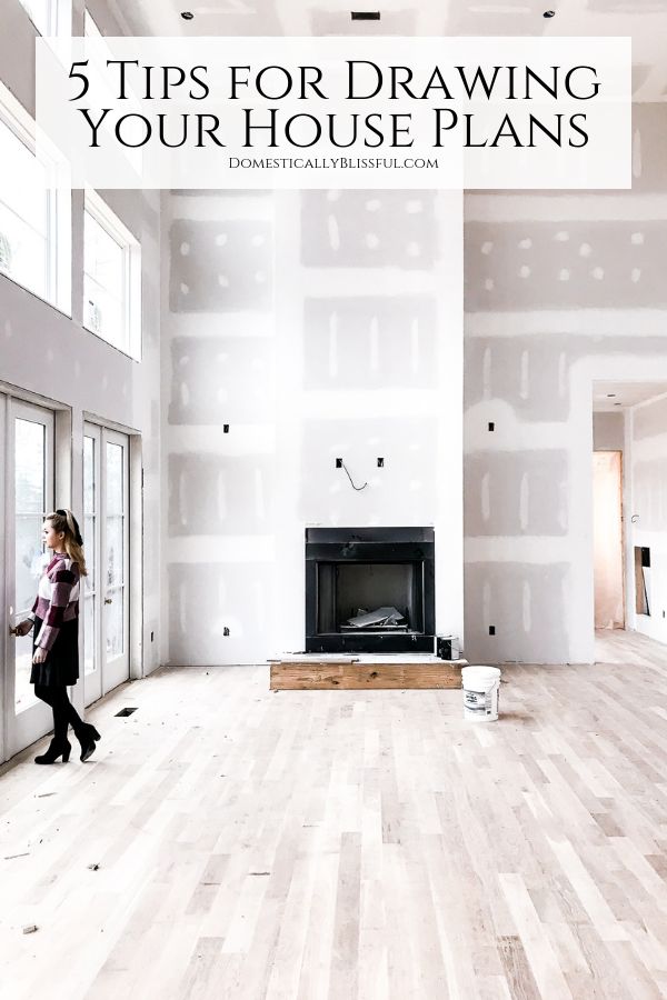 a woman walking through a large room with white walls and wood flooring in it