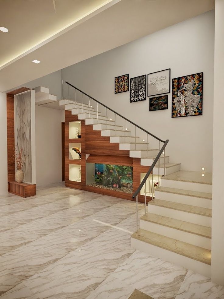 the stairs in this modern house are made of wood and marble, with pictures on the wall above them
