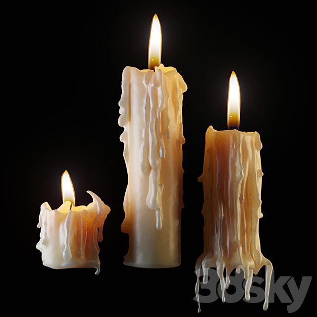 three lit candles with icing on them against a black background
