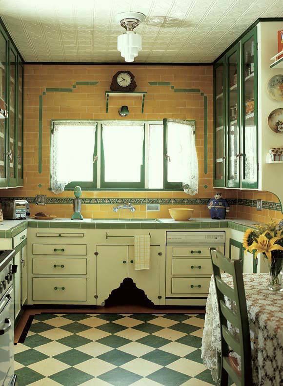 a kitchen with checkered flooring and green trim on the cabinets, counter tops, and sink