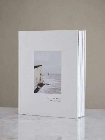 a white book with an image of a building on the front and back cover is sitting on a marble countertop