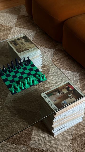 a stack of chess pieces sitting on top of a glass table next to a couch