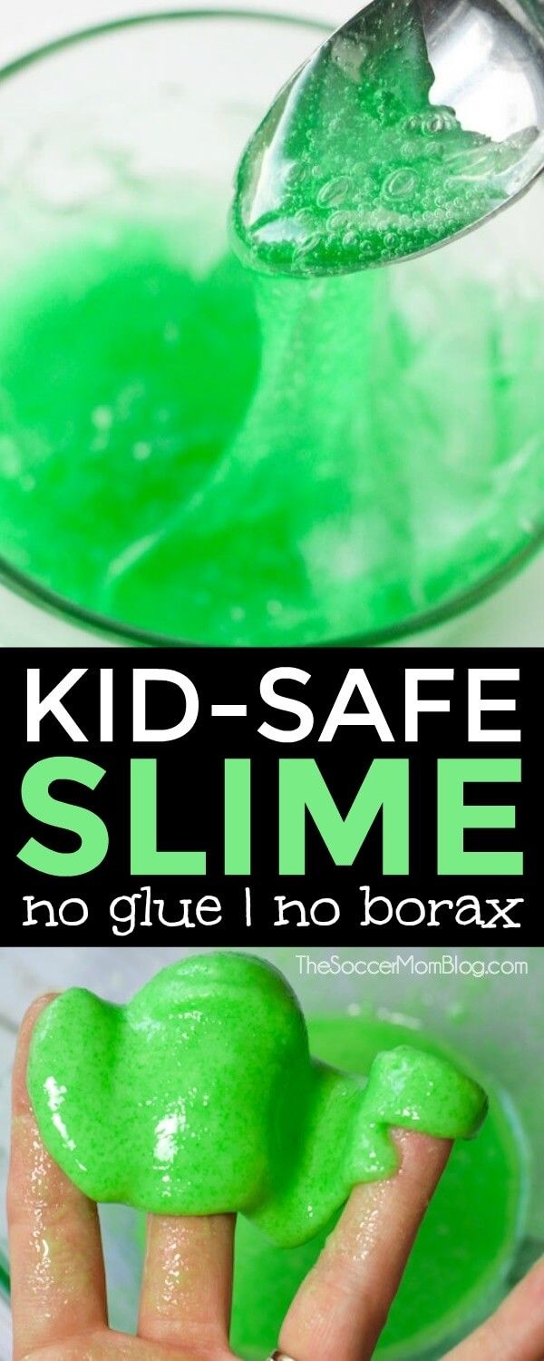 a kid's hand holding a green slime in front of a glass bowl
