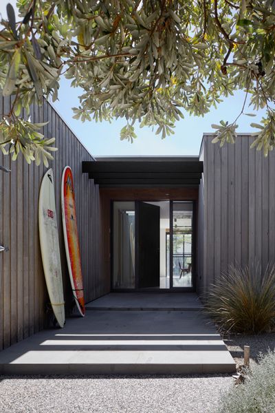 two surfboards are propped up against the wall in front of an entrance to a building