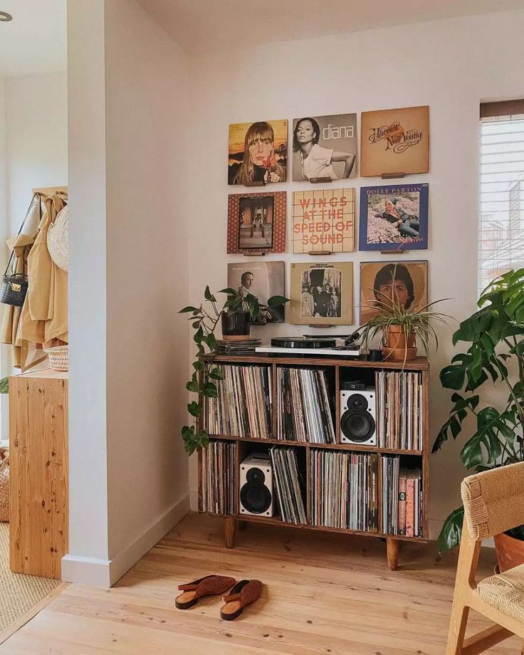 a record player sitting on top of a wooden cabinet in a living room next to a potted plant