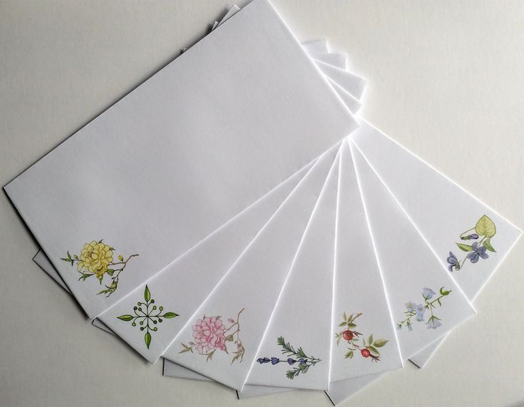 six white napkins with floral designs on them sitting on top of a table next to each other