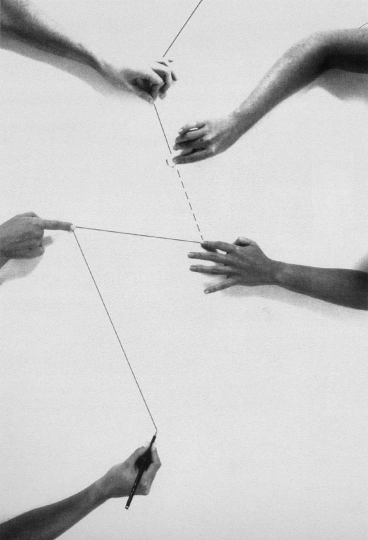 four hands reaching towards each other with one string attached to the other hand and holding another string
