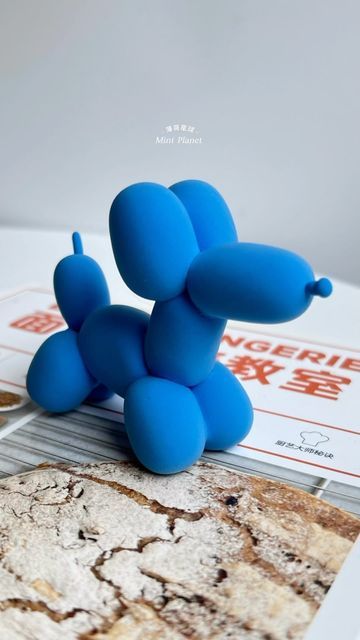 a blue dog figurine sitting on top of a table next to a magazine