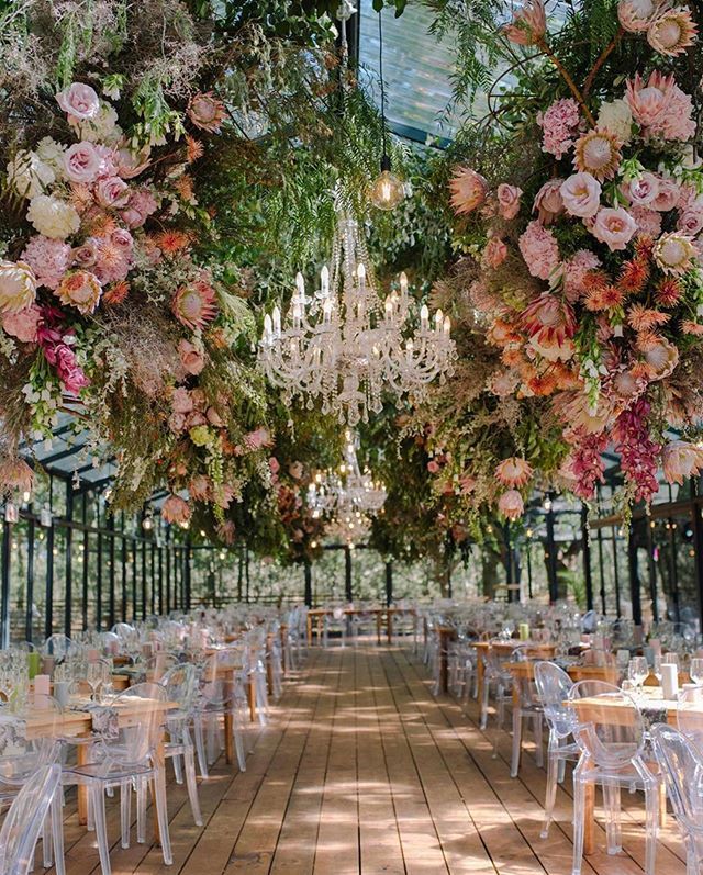 an outdoor wedding venue with chandeliers and flowers