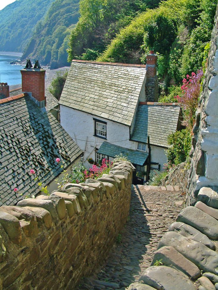 a cobblestone street leading up to a house on the side of a hill