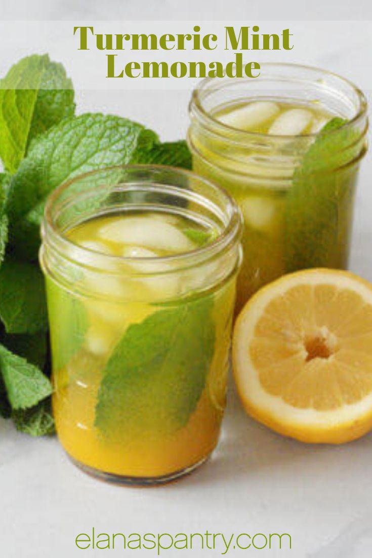 two mason jars filled with lemonade next to fresh mint leaves and sliced lemons