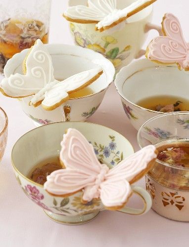tea cups with butterfly shaped cookies in them