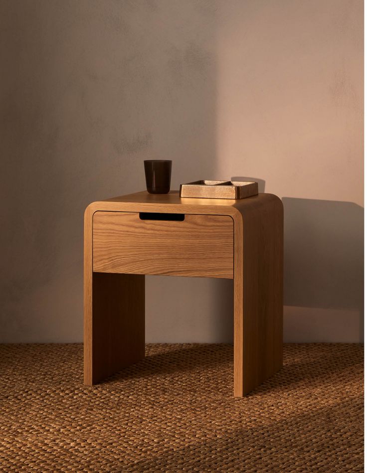 a small wooden table with a cup on it