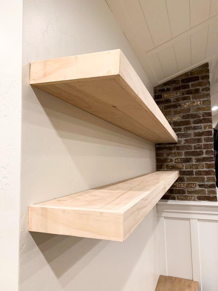 the shelves are made out of wood and have no one on them or they're attached to the wall