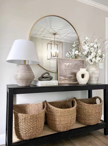 a console table with baskets under a mirror