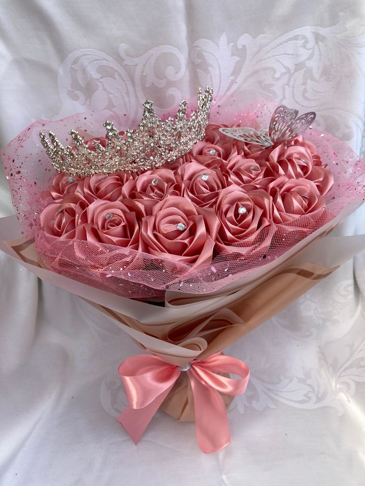 a bouquet of pink roses with a tiara on top
