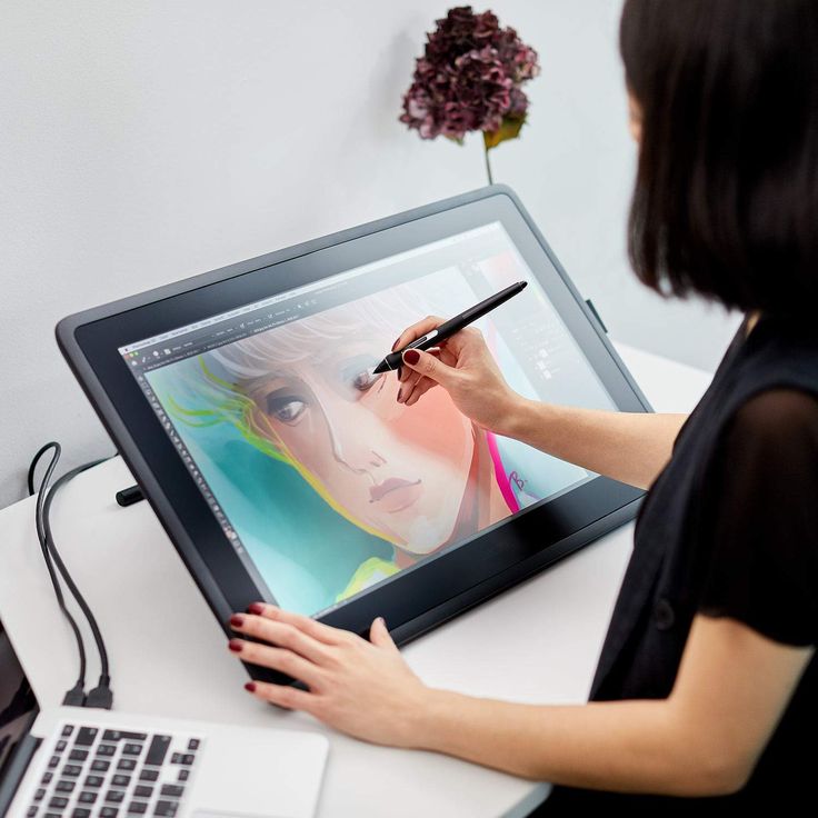 a woman is drawing on the screen of her tablet