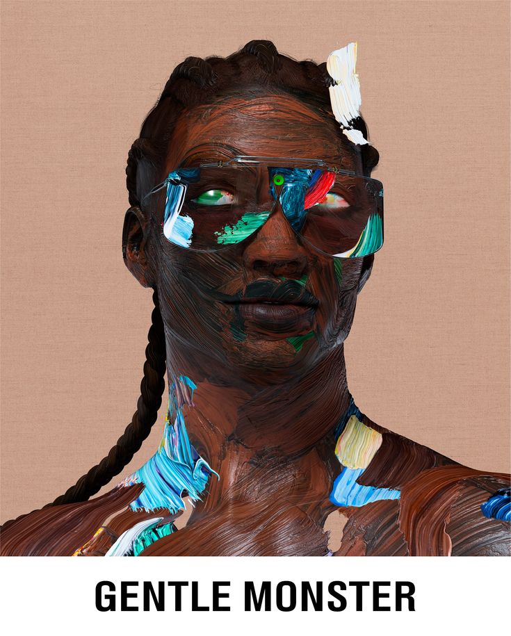 a woman's face is covered in multicolored paint and has braids