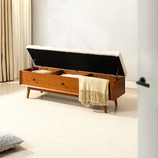 a wooden bench with two drawers and a blanket on the floor in front of it
