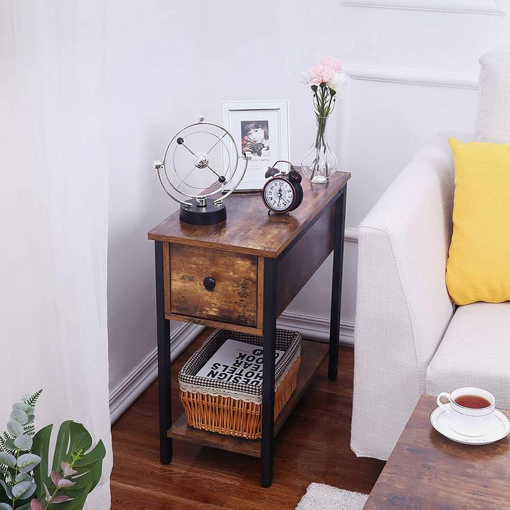 a wooden table with two drawers and a clock on it next to a white couch