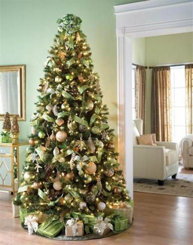 a decorated christmas tree in the corner of a room with green walls and wooden floors