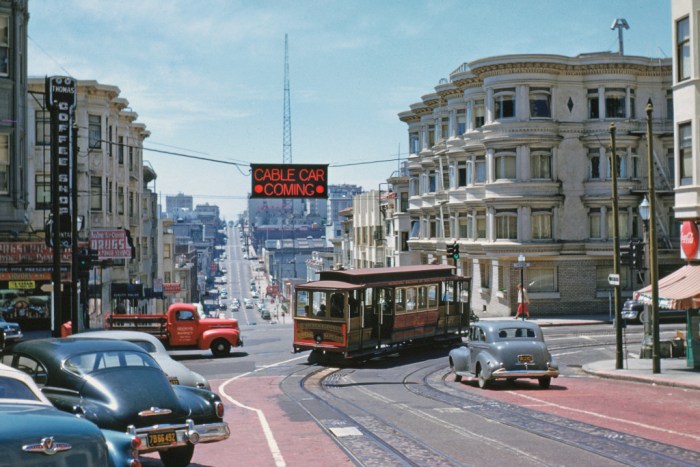 Downtown-bound O'Farrell, Jones & Hyde cable car No. 57 swings 'wrong-way' from Hyde into the oncoming traffic of Pine Street, (1954). The overhead neon sign warns motorists that an eastbound cable car is invading the one-way westbound street for two blocks, before it turns south on Jones Street. This mechanism was set up when the City made Pine one-way. Downtown interests longed to do the same with O'Farrell Street where two automobile garages were being built. The pressure for a one-way downtown street grid helped doom this fabled cable car line, which shut down two weeks after Walt Vielbaum took this great photo.