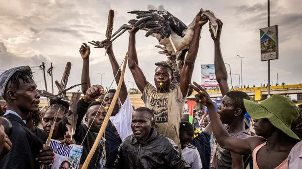Men carry a dead Marabou stork as they protest the presidential election victory of William Ruto - who defeated Raila Odinga in Kenya