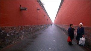 Two women talk in an alleyway in the imperial palace in Beijing