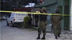 Soldiers patrol the exterior of the house where journalist Regina Martinez lived