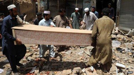 Local residents carry the coffin of a blast victim at the site of a bomb explosion in the main bazaar of Landi Kotal