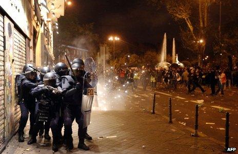 Spanish riot police protect themselves after coming under attack in Madrid, 14 November