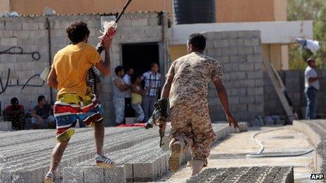 Members of security forces run away from clashes in Benghazi on 8 June