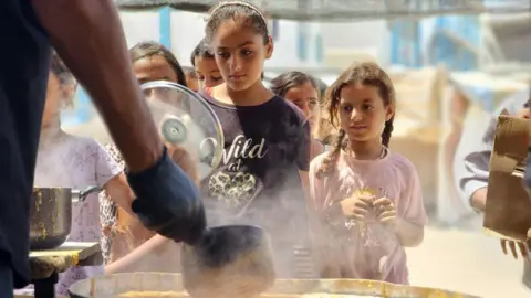Anadolu Displaced Palestinian children receiving food aid