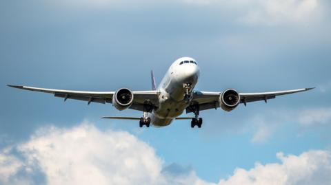 A passenger jet seen taking off against a blue sky