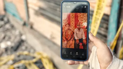 Ankit Srinivas Shivani shows a photograph of her parents Rajendra Kumar and Shobha Devi on her mobile phone