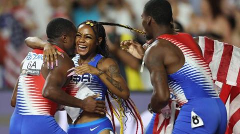 American sprinter Sha'Carri Richardson celebrates victory with members of the USA men's relay team