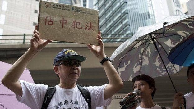 Protesters from Caring Hong Kong Power protest against Occupy Central outside a polling station during a civil referendum held by Occupy Central in Hong Kong on 22 June 2014