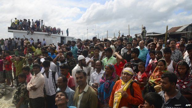 Bangladeshi onlookers gather near the scene where an overloaded ferry capsized in the Padma river in Munshiganj, some 30 kilometres (20 miles) south of the capital Dhaka, on August 4, 2014.