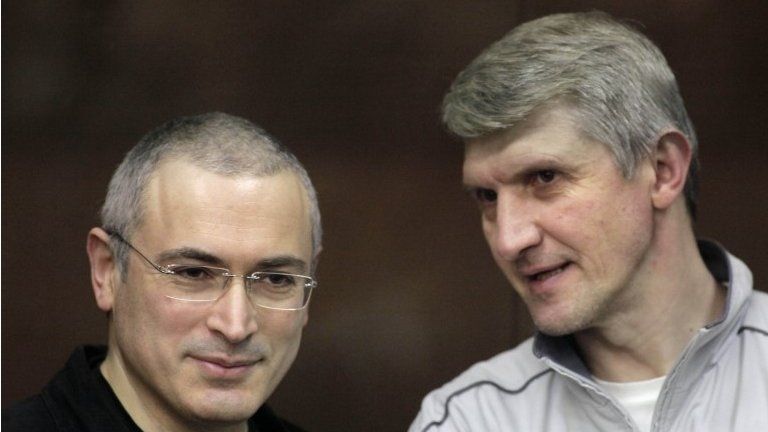 Platon Lebedev (right) and Mikhail Khodorkovsky (left) talk behind a glass enclosure at a court room in Moscow, Russia on 30 December 2010.