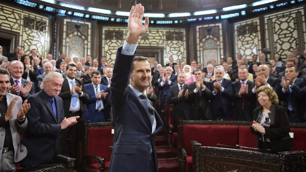 Bashar al-Assad waves to MPs on arrival at the Syrian parliament in Damascus (7 June 2016)