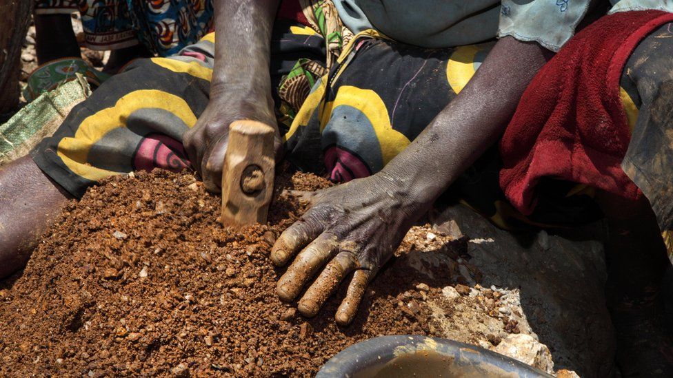 A woman breaks stones containing cassiterite ore at a mine in the Szibira district, Democratic Republic of Congo, in April 2009