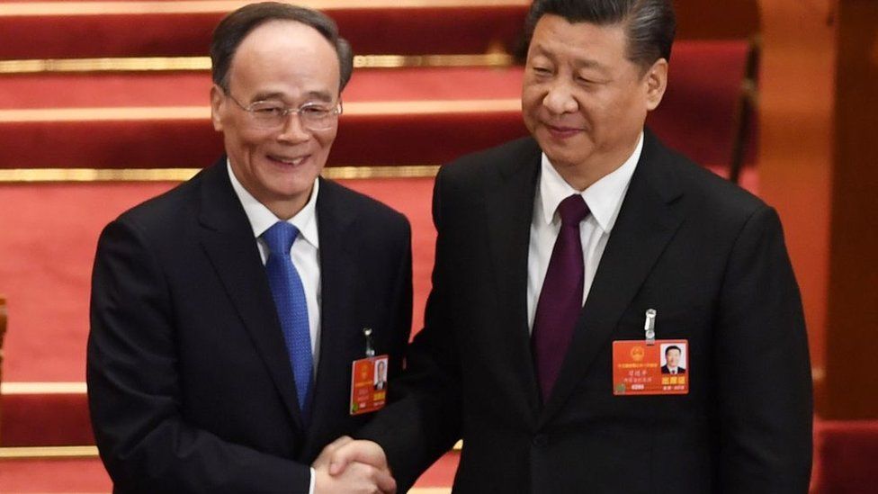 Wang Qishan, left, shakes hands with President Xi Jinping after becoming his deputy